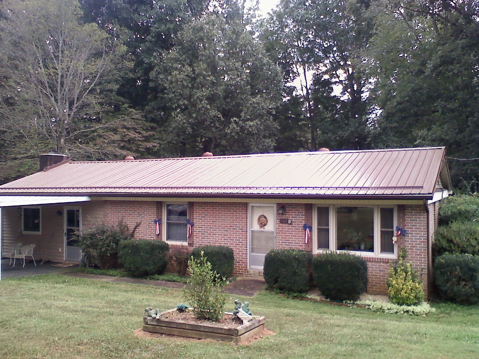 Bronze metal roof on a brick ranch home with a carport in Hamilton